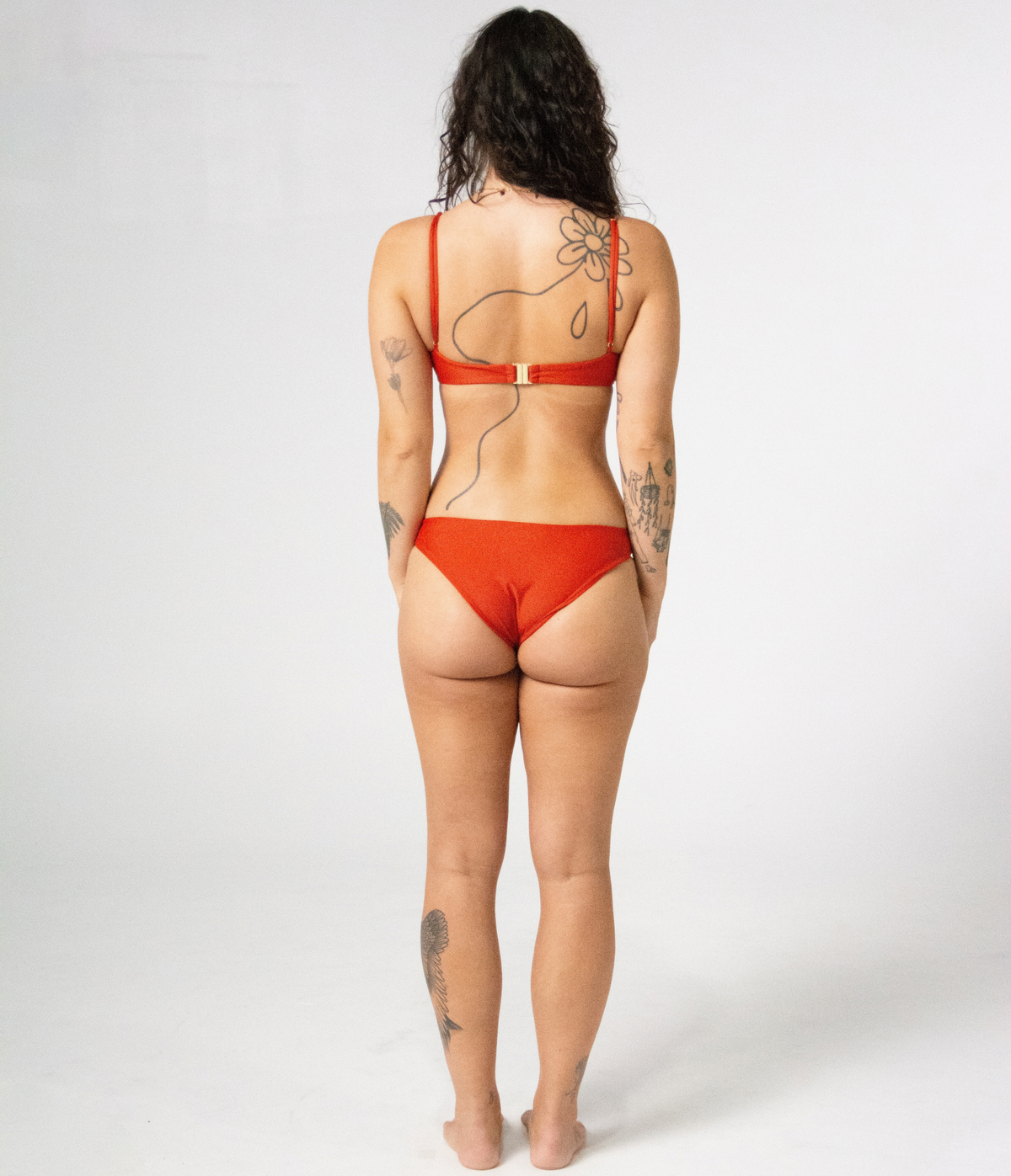 Crescent Scoop Top in Rust (orange), back view on model
