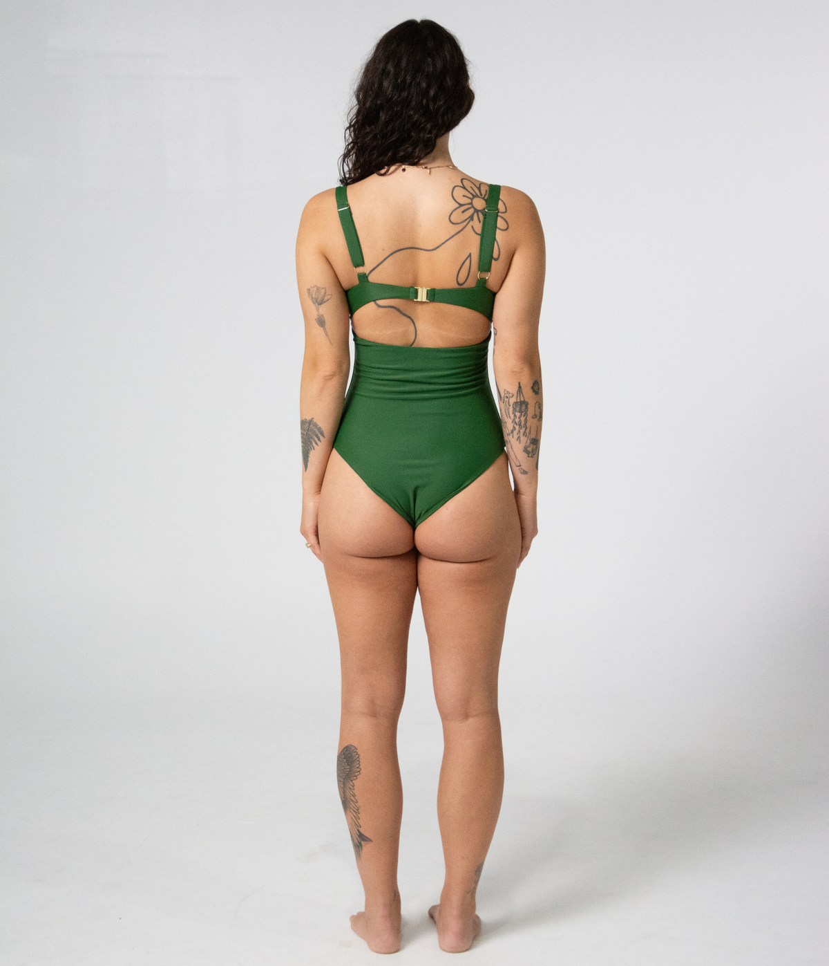Noosa One Piece in Fern (green), back view on model showing the cutout back and gold buckle