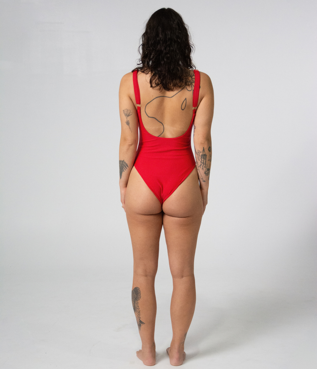 Mali One Piece in Scarlet (red), back view on model showing the scoop back and gold strap hardware