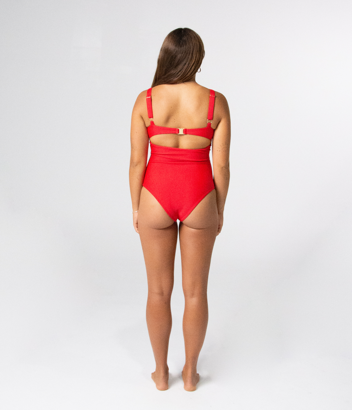 Noosa One Piece in Scarlet (red), back view on model showing the cutout back and gold buckle