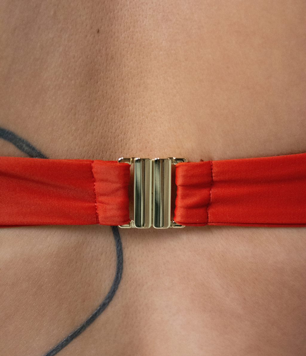 Close-up of the buckle on the Crescent Scoop Top in Rust (orange)