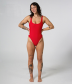 Mali One Piece in Scarlet (red), front view on model with hands at her sides