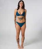 Byron Low Rise Bottoms in Peacock (teal), front view on model with hands behind her back