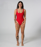 Mali One Piece in Scarlet (red), front view on model with hands on thighs, showing the square neckline