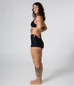 Burleigh Swim Shorts in Noir (black), left side view on model showing the high waist
