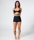 Burleigh Swim Shorts in Noir (black), front view on model with hands behind her back