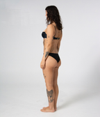 Byron Low Rise Bottoms in Noir (black), left side view on model showing the low rise at the hip