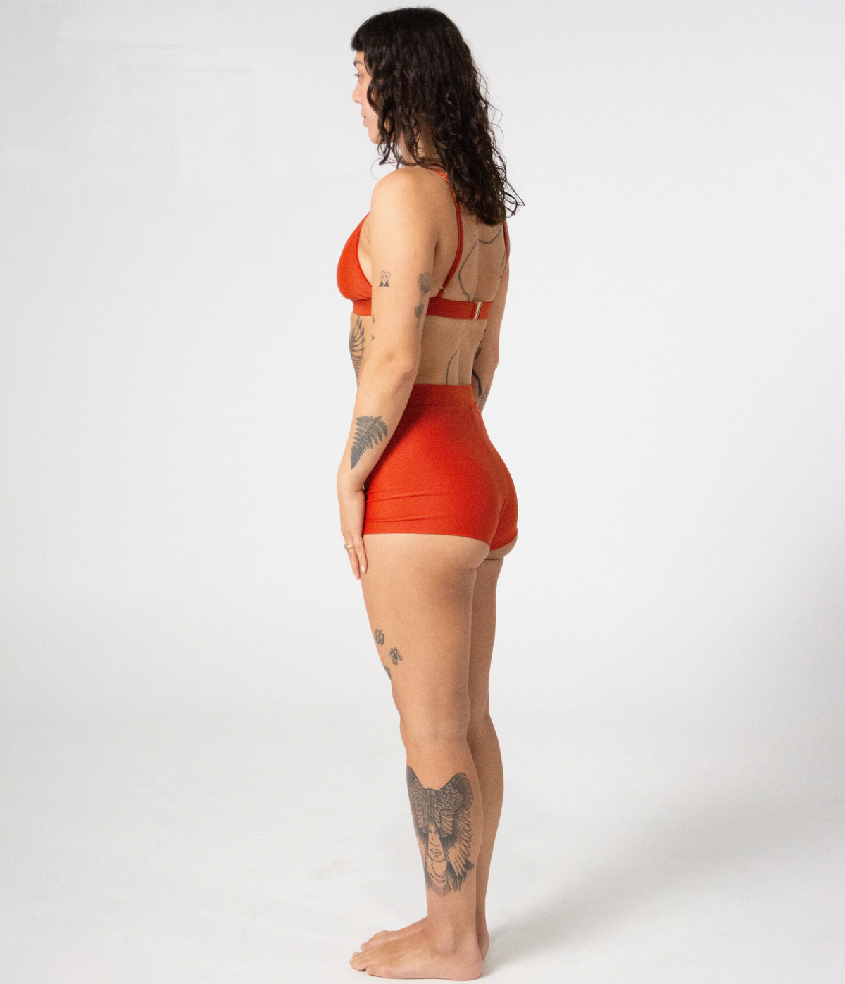 Kirra Triangle Top in Rust (orange), left side view on model